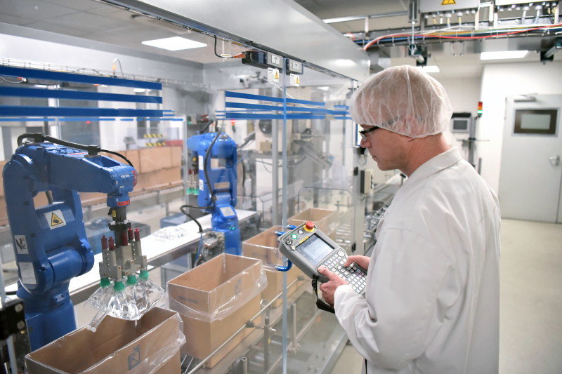 A Senior Lab Technician Operating With Collaborative Robot In The Pharma Industry.